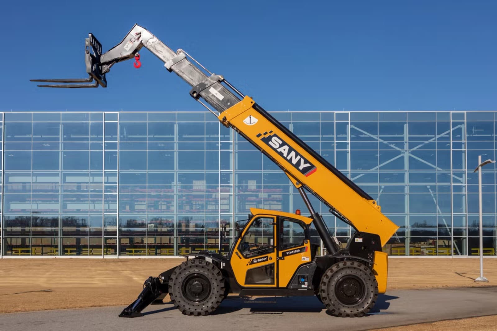 Telehandler con brazo telescópico extendido y aditamento de horquillas